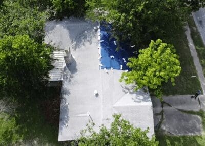 A white building with trees and benches around it