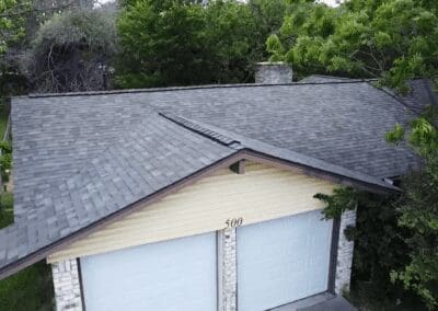 A garage with two doors and a roof that has been damaged.