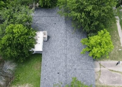 A bird 's eye view of trees and a concrete driveway.