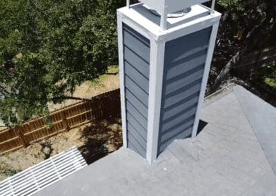 A chimney with a roof and a fence