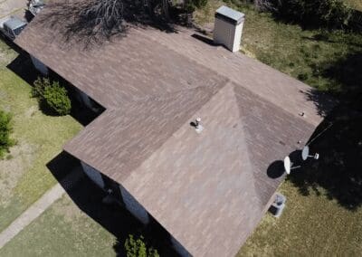 A brown roof with trees in the background