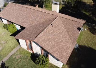 A brown roof with a white brick house