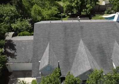 A large gray roof with trees in the background.