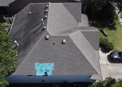 A blue sign is on the roof of a house.