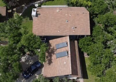 A house with brown roof and car parked in front of it.