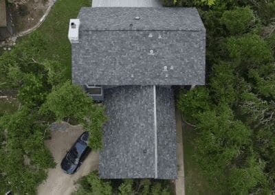 A car parked on the side of a road near trees.