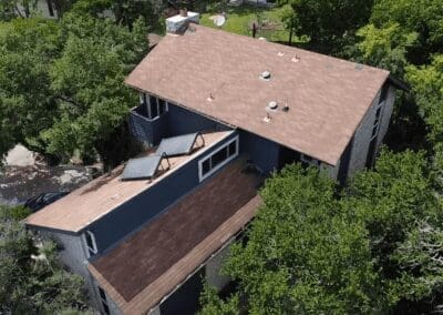 A house with a roof that has been covered in brown shingles.