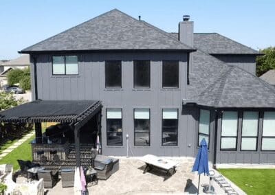 A large gray house with a patio and covered deck.