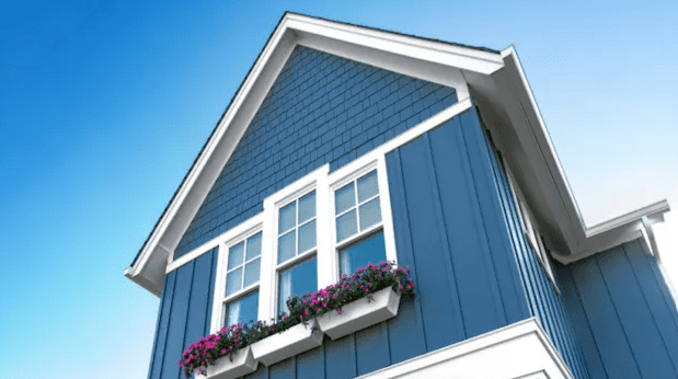 A blue house with flowers in the window.